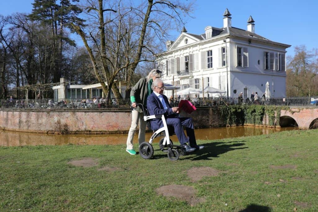 Older couple walking outdoors together with a rollator