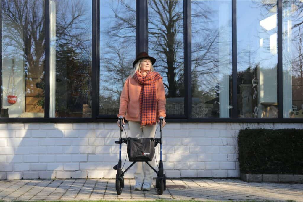 Senior standing with a rollator walker, ready to add accessories like a bag or cup holder