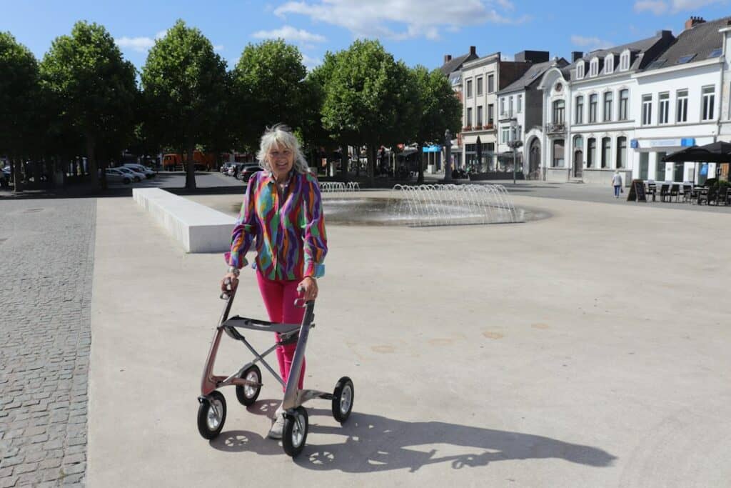 Elderly woman using a compact walker in a town square