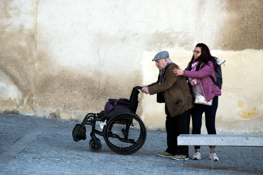Caregiver walking beside an older man to steady him - gait belt guide