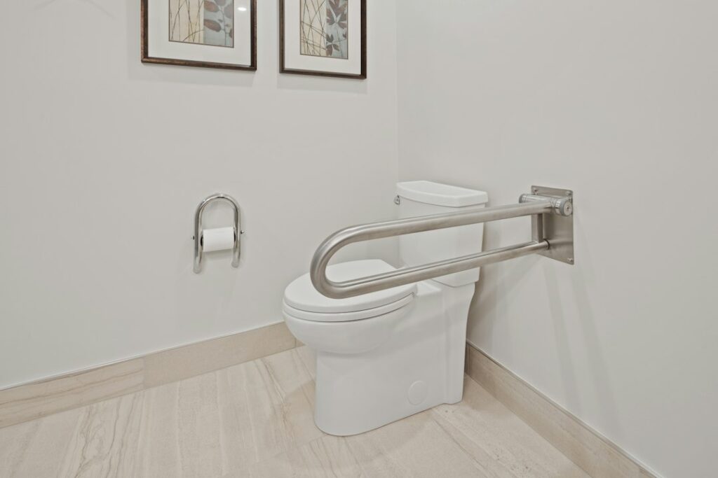 Best Grab Bars for Seniors: 5 Safe Picks + Where to Install Them 1 Stainless steel grab bar mounted on the wall beside a toilet in an accessible bathroom