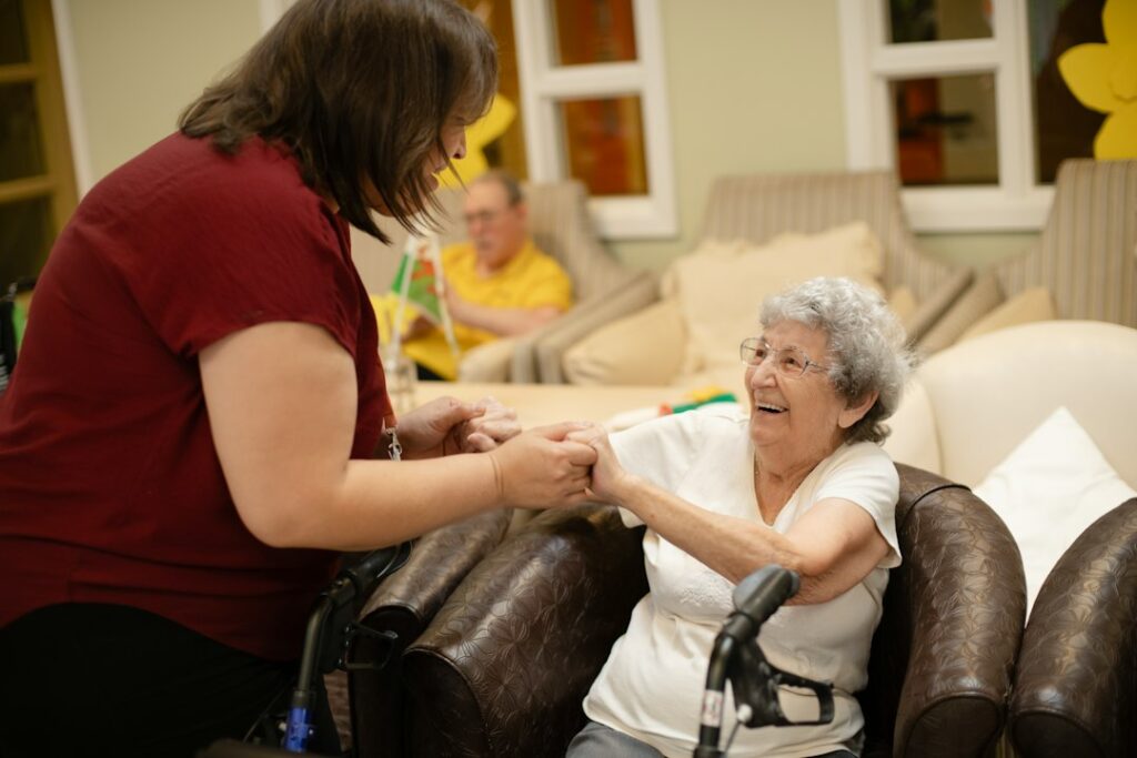 Caregiver helping an older woman stand up with a walker at home